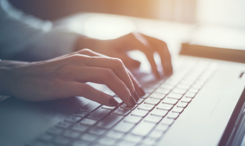 Male's hands typing on a laptop