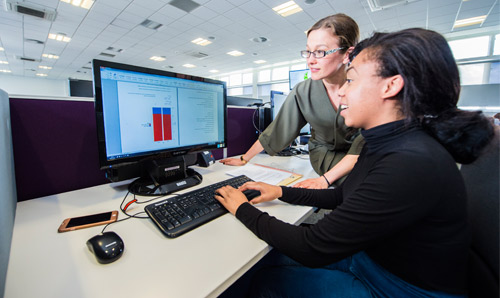 Teacher and student working on computer