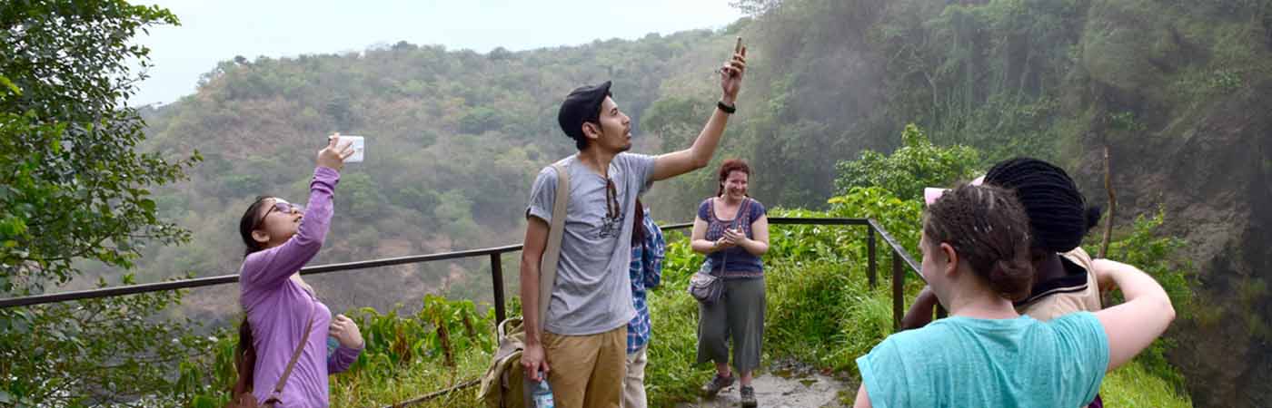 Students in Uganda up a mountain taking photos